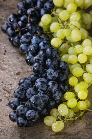Bunches of ripe wet red and white grapes over old texture metal background. Close upの写真素材