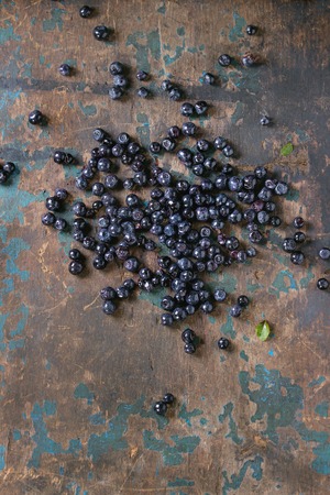 Heap of forest blueberries over old wooden textured background. Top view with copy space.の写真素材