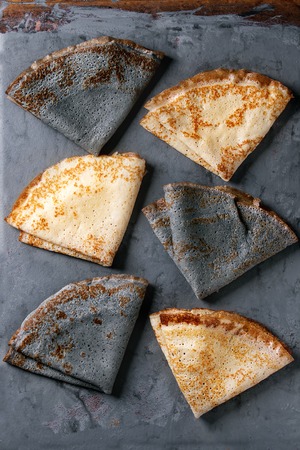 Variety of black and white empty crepe pancakes. Over gray metal background. Top viewの写真素材