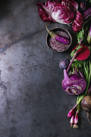 Assortment raw organic of purple vegetables mini eggplants, spring onion, beetroot, radicchio salad, plums, kohlrabi, flower salt over dark metal background. Top view with space. Food frameの写真素材