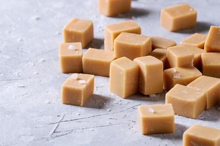 Salted caramel fudge candy over grey texture background. Close up, spaceの写真素材