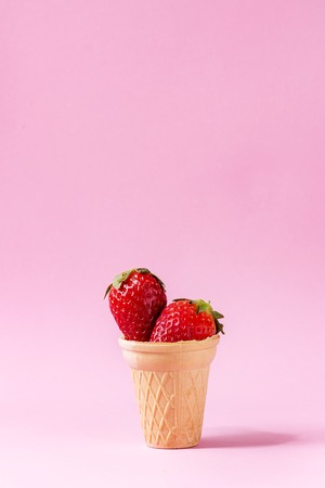 Fresh strawberries in waffle cup over pink pastel pin-up background. Copy space.の写真素材
