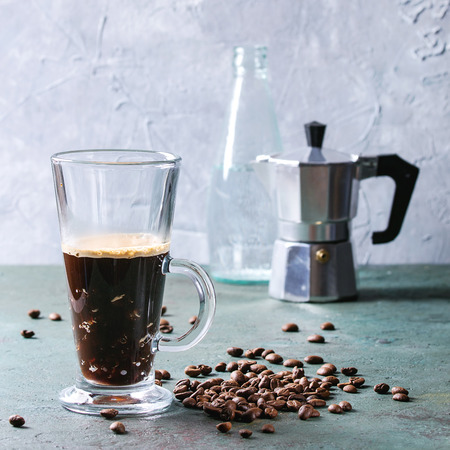Fizzy iced Coffee espresso with bottle of sparkling water, coffee maker and roasted beans over grey green texture table. Modern drink. Copy space. Square imageの写真素材