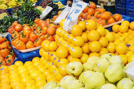 Turkish farmer market. Heap of fresh organic fruits on the counter oranges, apples, grapes, pomegranates, tangerines, bananas, persimmonsの写真素材