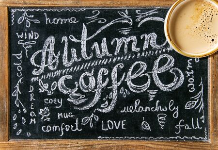 Cup of espresso coffee on vintage chalkboard with lettering Autumn coffee as background. Top view....