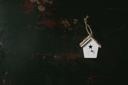 Christmas toys wooden birdhouse over black wooden background. Christmas and New year decorations or...