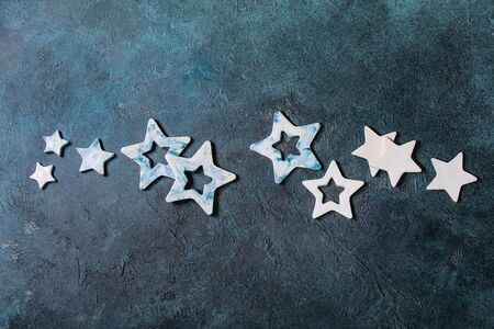 Christmas decoration ceramic stars white and blue glazed, different size, over blue texture background. Christmas and New year greeting card. Flat lay, space.の写真素材