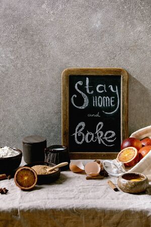 Ingredients for baking. Stay home quarantine isolation period concept. Vintage chalkboard with handwritten chalk lettering Stay home and bake. Grey texture backgroundの写真素材