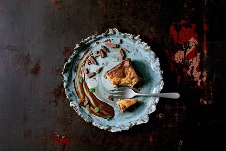 Trend baking Brookies chocolate brownies and cookies homemade cake eaten slice, chocolate sauce, mint, fork in blue ceramic plate on black background. Flat lay, spaceの写真素材