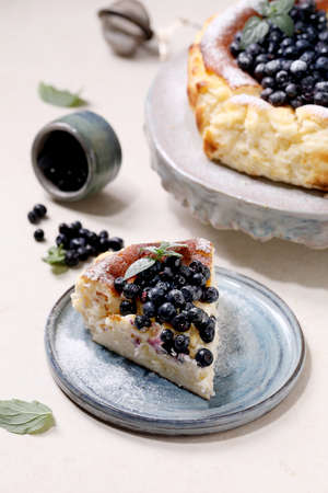 Piece of homemade blueberry baked soft cheesecake san sebastian on ceramic plate, decorated by fresh...