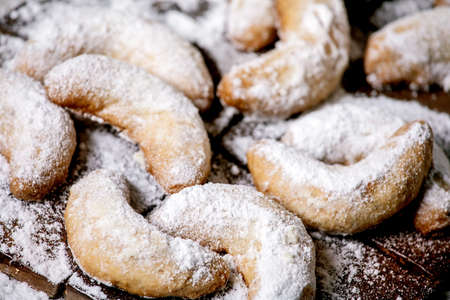 Homemade traditional Christmas shortcrust cookies vanilla crescents with icing sugar over dark ceramic tile background. Top viewの写真素材