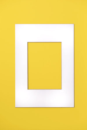 Sinple white paper frame over yellow background. Creative layout. Space for text or designの写真素材