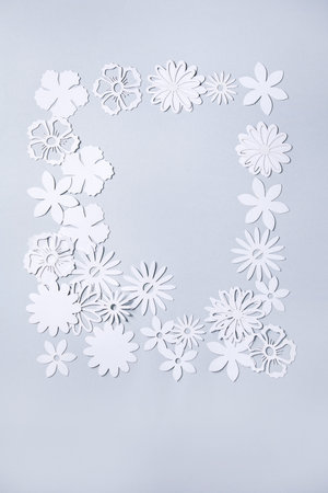Creative layout variety of white paper flowers as frame over gray background. Flat lay, copy spaceの写真素材