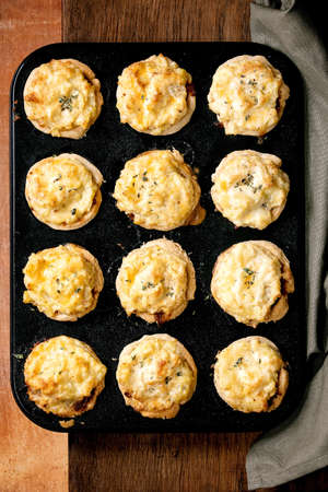 Homemade Mince meat shortcrust pastry mini pies with mashed potato and thyme in black baking tray