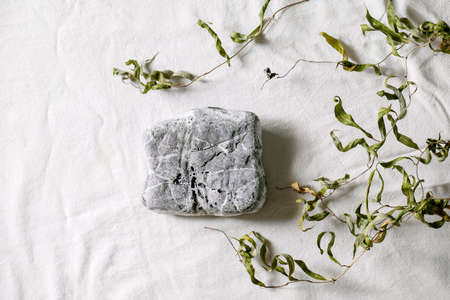 Abstract natural scene with geometrical square stone as podium or pedestals for products presentation or exhibitions on white textile with branch. Scene to show any products for advertising. Flat layの写真素材