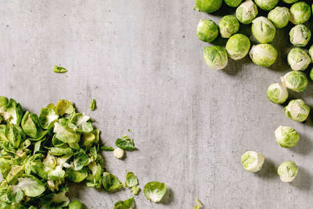 Heap of peeled raw organic brussels sprouts mini cabbage cabbage peel as frame border over light grey background. Vegetables healthy eating. Top viewの写真素材