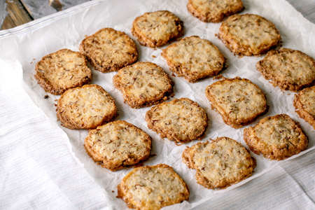 Homemade square shortbread sugar cookies with nuts and white chocolate on baking paper on white...