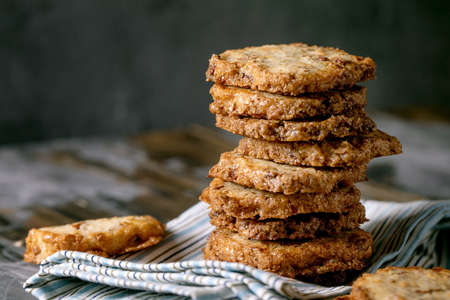 Homemade square shortbread sugar cookies with nuts and white chocolate in stack on linen kitchen...