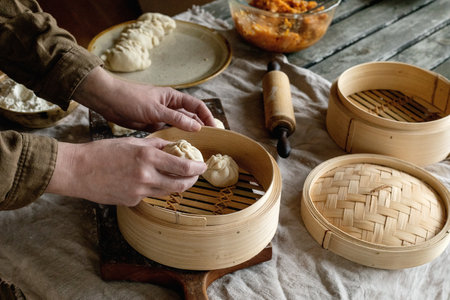 Making Asian steamed dumplings with vegetable filling. Female hands shaping dumplings on floured...