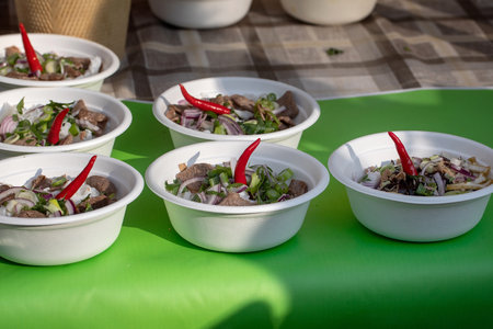Street food festival in Europe. Traditional Vietnamese pho-bo in disposable bowls on counter, fast...