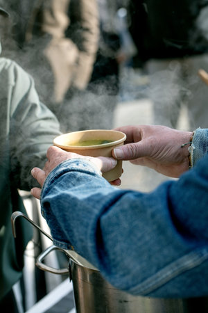 European street food festival. Customer receiving disposable bowl hot soup vendor hand. Traditional...