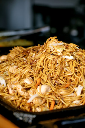 Street food festival in Europe. Asian fast food at market stall. Close-up of stir-fried chicken and...