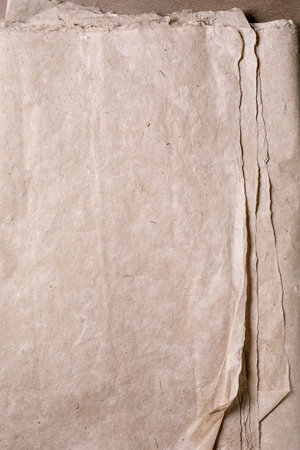 Aged mulberry handmade parchment paper with rough edges natural beige texture visible fibers. Perfect background for vintage design scrapbooking invitations.の写真素材
