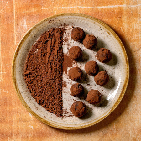 Homemade dark chocolate cocoa truffle candy and cocoa powder on ceramic plate over stone background. Handmade food sweet gifts for any holidays. Flat lay, copy spaceの写真素材