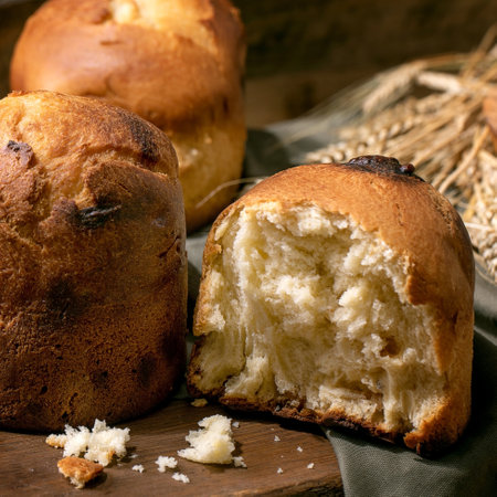 Homemade traditional brioche wheat bread, whole and half. Standing on wooden kitchen table. Close upの写真素材
