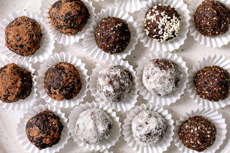 Homemade healthy energy raw vegan balls varieties with cocoa seeds nuts. Different coatings including powdered sugar sesame seeds cocoa powder. Top view.の写真素材