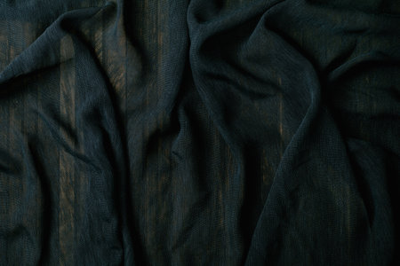 Dark green crumpled fabric with natural wrinkles and folds creating textured surface. Soft cotton or linen material with organic creases and shadows.の写真素材