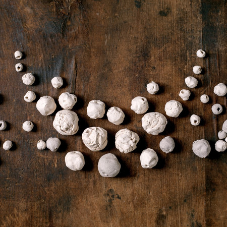Various shapes unglazed white handmade ceramic beads. Hobby, jewelry assembly, DIY jewelry. Workshop idea. Dark wooden background, top view.の写真素材