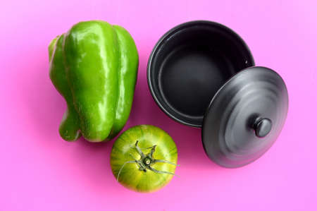 Black pot, green pepper and green tomatoの写真素材