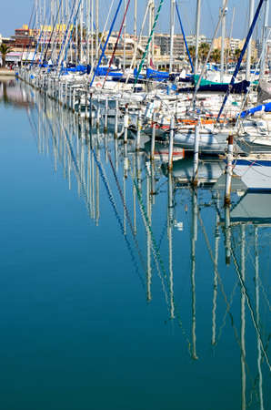 Sailing boats reflecting in the marinaの写真素材