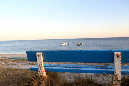 Empty wooden blue bench at the seashore