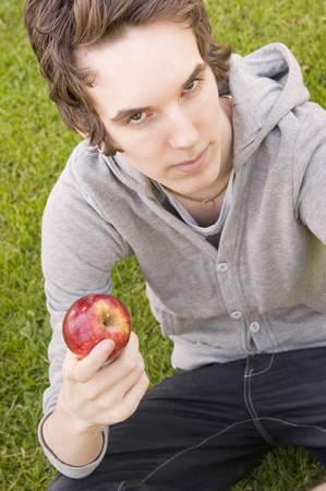 Young man holding an appleの写真素材