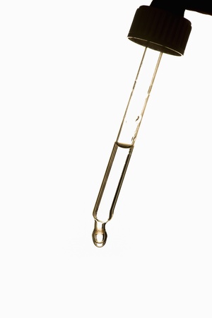 Dropper with clear fluid used for scientific research on white backgroundの写真素材
