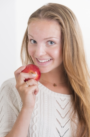 Beautiful healthy young woman eating fruitの写真素材