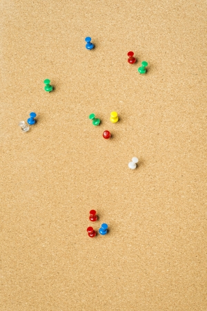 Pins stuck in surface of bulletin board with cork textureの写真素材