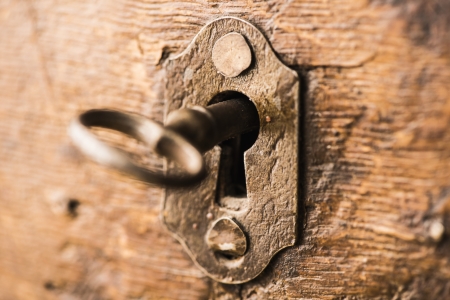 Old antique skeleton key in lock of wooden cabinetの写真素材