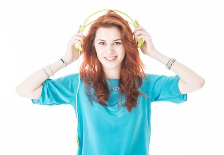 Lifestyle portrait of smiling pretty young woman with green headphonesの写真素材