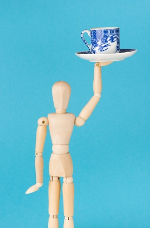 Conceptual image of work at cafe. Wood figurine waitress serve cup of coffee.の写真素材