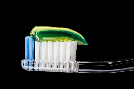 Close-up detail of transparent toothbrush and green gel toothpasteの写真素材