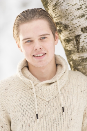 Christmas scene with natural looking teenage male outdoors in snow covered winter landscape.の写真素材