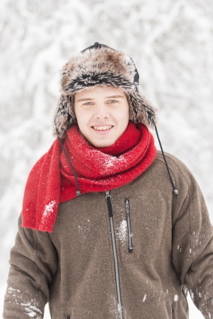 Christmas scene with natural looking teenage male outdoors in snow covered winter landscape.の写真素材