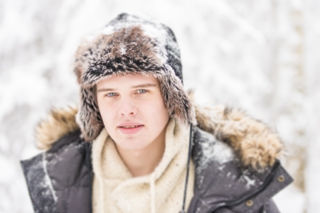 Christmas scene with natural looking teenage male outdoors in snow covered winter landscape.の写真素材