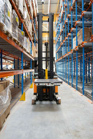 Interior view of a warehouse with racks, pallets, goods, forklifts