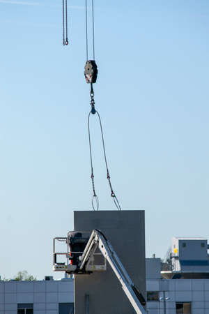 Cranes and lifts carrying concrete walls for installation on a warehouse and office construction...