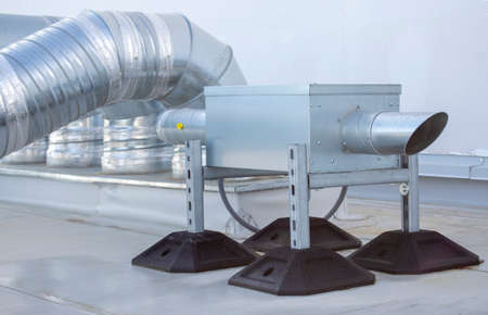 Air extractor and large galvanized steel pipes on the roof of a warehouse