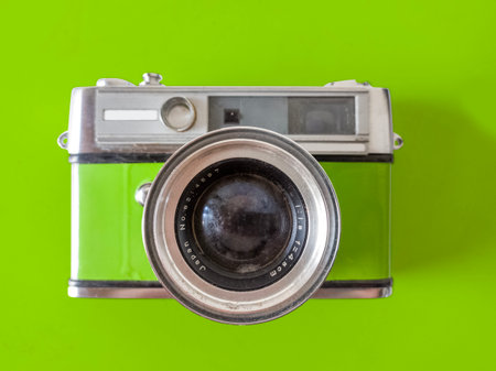 Nice green 35mm camera with lens on green backgroundの写真素材